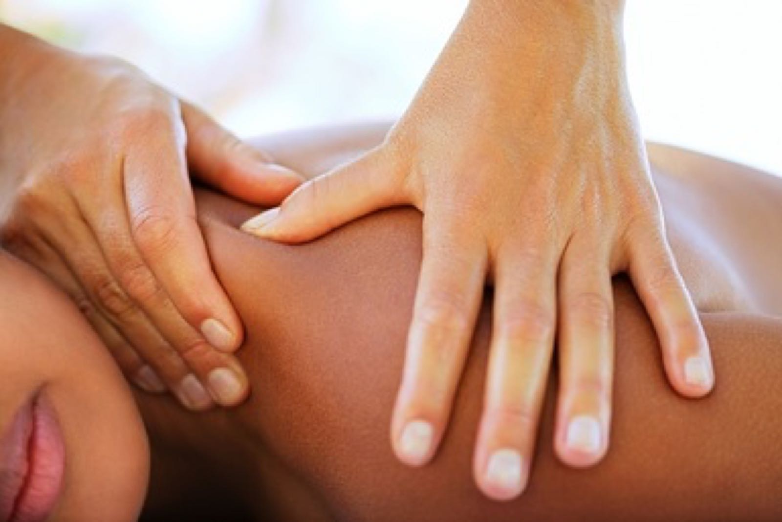 Massage therapist's hands on a client's shoulder