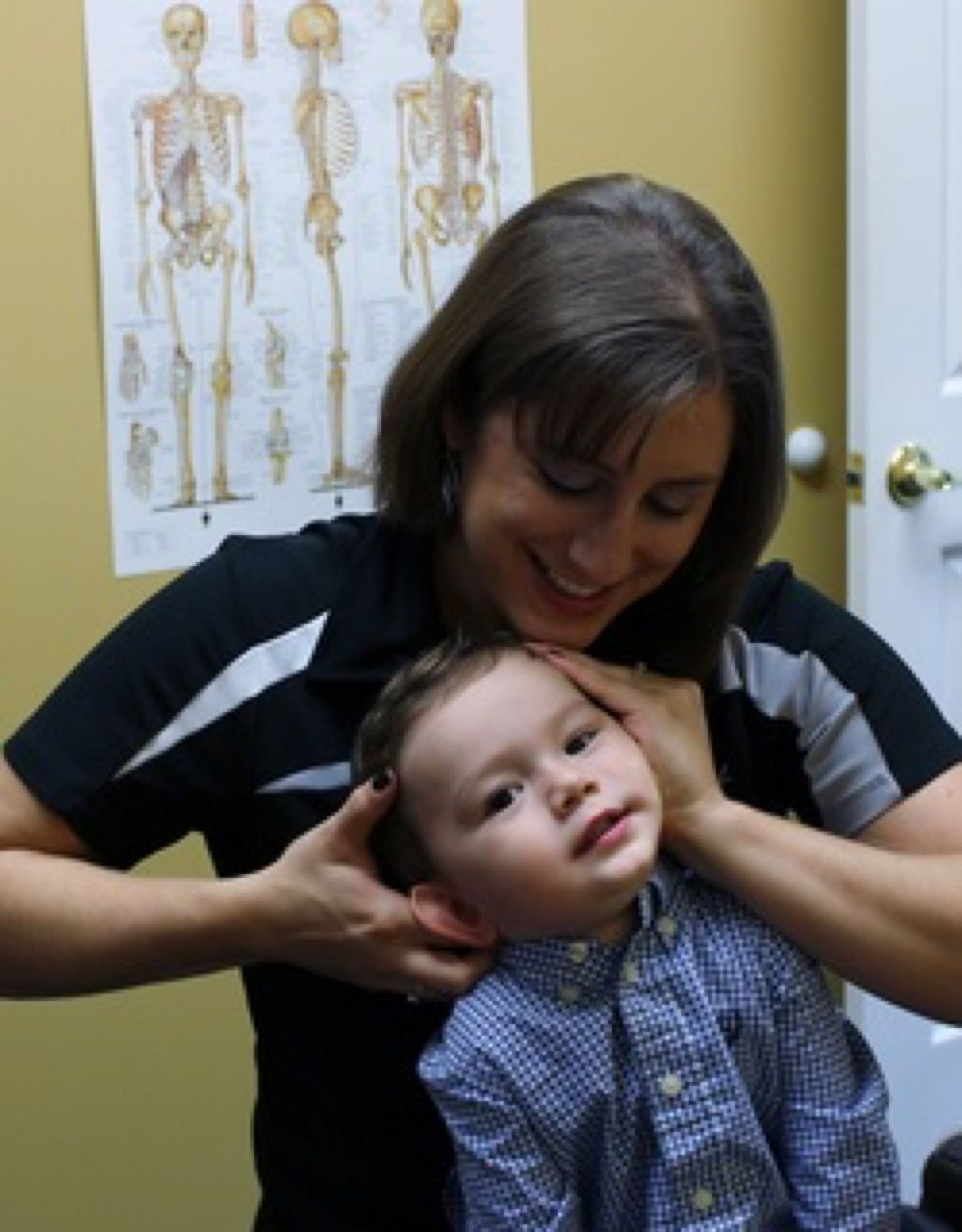 Chiropractor gently adjusting a young child