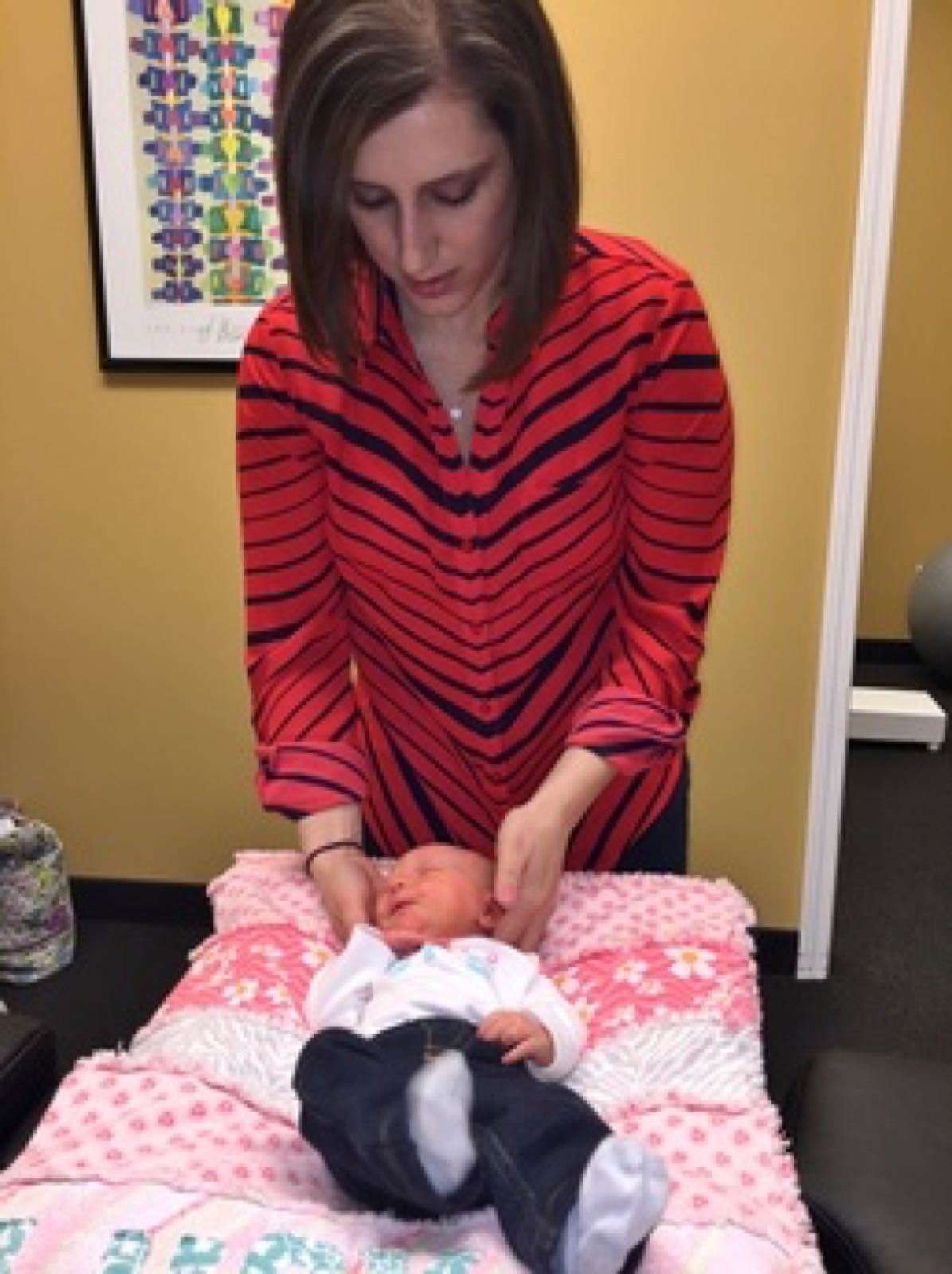 Chiropractor working with a baby on a table